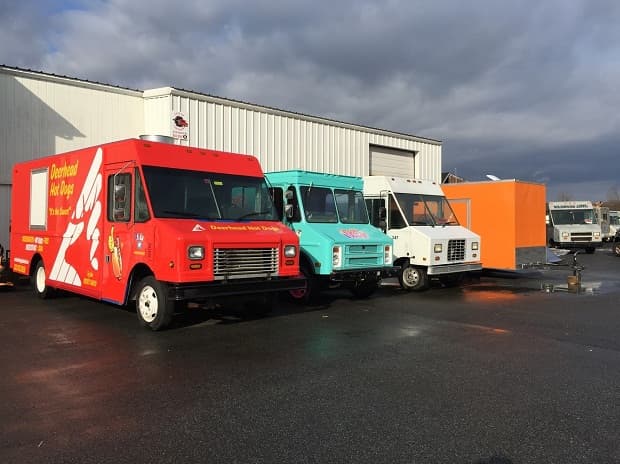 Three Custom Concessions food trucks parked outside.